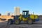 Front-end loader working at construction site. Earth-moving heavy equipment for road work. Public works, civil engineering, road