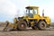 Front-end loader working on construction site during the renovation of the road.