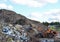 Front-end loader works in a landfill for the disposal of construction waste and other debris. Industrial waste treatment