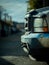 Front end of a white truck with a blurred alley in the background