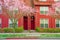 Front entrance of red townhouse with pink cherry blossom in Seattle, Washington, USA