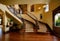 front entry foyer of a luxurious home rich wood tones staircase bench with a welcoming feel