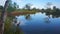 In front of the eyes lay an amazing sight, where a calm pond reflects the beauty of the blue sky and the trees around it.