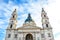 Front facade of St. Stephen`s Basilica in Budapest, Hungary on with blue sky and clouds above. Roman Catholic basilica built in