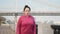 Front follow shot of attractive lady doing nordic walking training in city along river and city bridge. Wellness concept