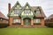 front gable of brick tudor with green lawn in foreground