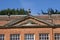 Front gable with sculptured pediment and urns