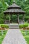 Front of gazebo with wooden benches and paver path.