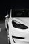 Front headlight, bumper and exterior of Tesla Motors company white electric car at night