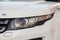 Front headlight view of Range Rover Land Rover Evoque in white color after cleaning before sale in a winter day and snow