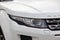 Front headlight view of Range Rover Land Rover Evoque in white color after cleaning before sale in a winter day and snow