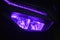 The front LED light of a purple automatic motorbike