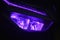 The front LED light of a purple automatic motorbike