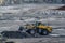 Front loader with large wheels and steel chains. Opencast mining quarry with machinery and mining equipment. Limestone mining for