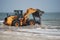 Front loader truck on beach in water