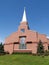 Front of a modern red brick church