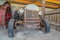 Front of an old and vintage tractor against stone wall and roof of a farm barn