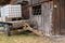 Front of an old wooden barn stands a trailer with a big water canister