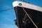 The front part of a moored huge ship liner against the blue sky close-up bottom view