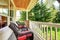 Front porch with brown chairs and red cushions.