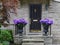 Front porch of stone faced traditional house bright hydrangea flowers