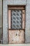 Front shoot of open brown colored metal door with traditional turkish pattern by stone wall