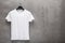 Front side of male white cotton t-shirt on a hanger