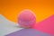 Front side of a mini pink silicone facial cleansing brush on colorful background