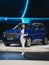 Front side view of new Chinese blue crossover Haval H6 car with stand presenter girl