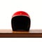 Front side view of red color vintage style motorcycle helmet on natural wooden desk.Concept classic object isolated