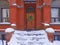 Front steps of old brick house covered in snow