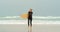 Front view of active senior African American female surfer with surfboard running on the beach 4k