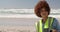 Front view of African american female volunteer cleaning beach on a sunny day 4k