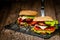 Front view of appetite burgers with beef, cheese, tomato, lettuce on stone board. Selective focus