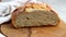 Front view of artisan loaf bread. Womanâ€™s hands take off a front part of bread to show the inner part of bread.