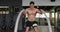 Front view athletic Caucasian man working out with battle ropes