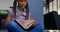 Front view of attentive African American schoolgirl reading a book in library at school 4k