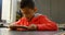 Front view of attentive Asian schoolboy studying with digital tablet in classroom at school 4k