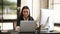 Front view of attractive businesswoman in black suit working with multiple device.