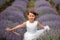 Front view of a beautiful little girl enjoying and running between rows of blooming lavender