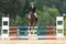 Front view of beautiful young horsewoman jumping