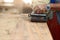 Front view of belt sander working on a piece wood with hands of worker with copy space. Selective focus and shallow depth of field