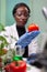 Front view of biologist reseacher woman analyzing tomato injected with chemical dna