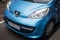 Front view of blue Peugeot 106 parked in the street by rainy day