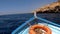 Front view boat with lifebuoy,floating on blue sea.