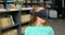 Front view of Caucasian schoolgirl using virtual reality headset in library at school 4k