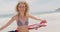 Front view of Caucasian woman with waving American flag dancing on the beach 4k