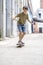 Front view of cheerful skater boy riding on the city in a sunny day