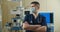 Front view close up of a Caucasian surgeon male healthcare worker in a hospital putting on a surgical mask.Healthcare