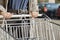 Front view closeup with a selective focus of a teenage girl moving a shopping cart outside a supermarket